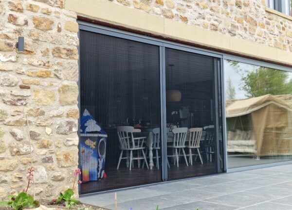 Plisse fly screens patio doors Plisse fly screens fitted across sliding patio doors