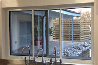 Sliding fly screens fitted to a kitchen window above a sink
